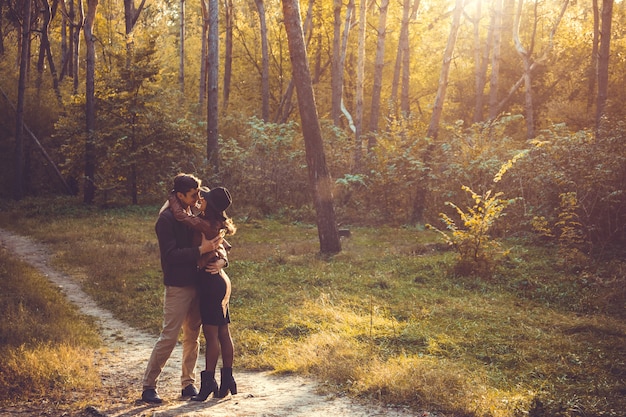 Joven Pareja De Enamorados Abrazándose Y Besándose En El Bosque De Otoño Foto Premium