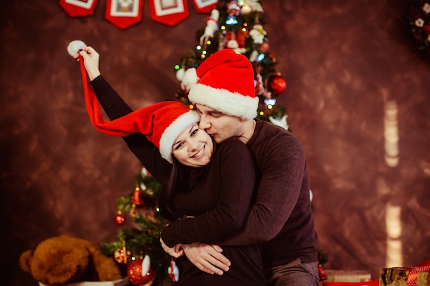 Joven Pareja Feliz Abrazando Cerca Del Arbol De Navidad Foto Gratis