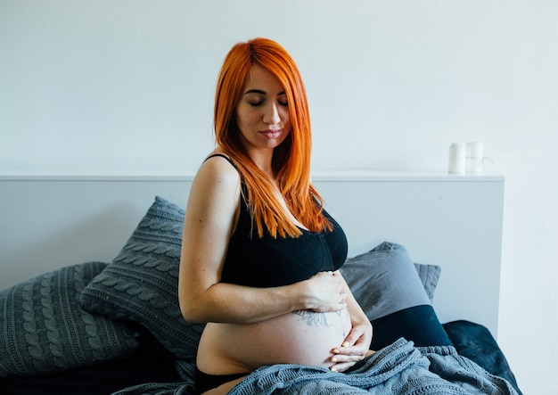 Joven Pelirroja Posando En La Cama Foto Gratis