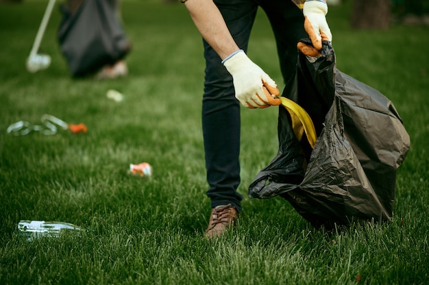 Joven Recoge Basura En Una Bolsa En El Parque, Ofrecerse Como ...