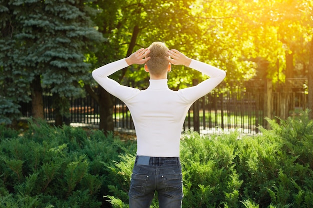 Un Joven Rubio Vestido Con Un Su Ter Blanco Y Jeans Negros Est De