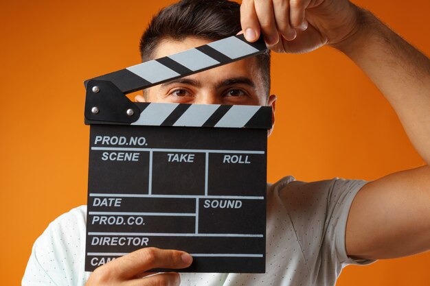 Joven sosteniendo el tablero de la chapaleta de la película Foto Premium