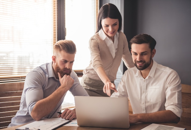 Jóvenes empresarios exitosos están utilizando una computadora portátil. Foto Premium