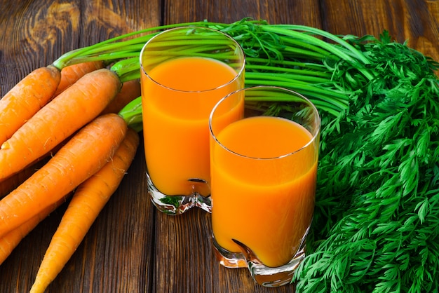 Jugo de zanahoria en vaso y zanahoria fresca Foto Premium 