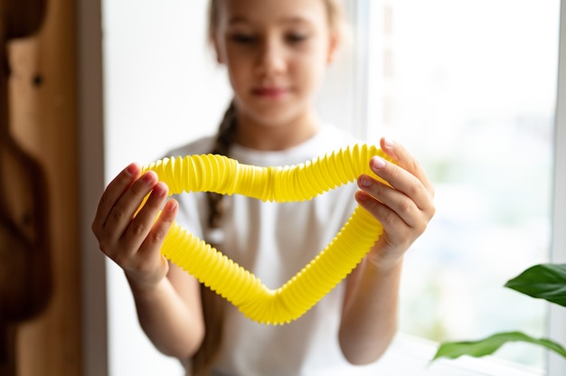 Juguete Plástico De Tubo De Pop Sensorial Antiestrés En Manos De Un Niño Una Niña Pequeña Feliz 