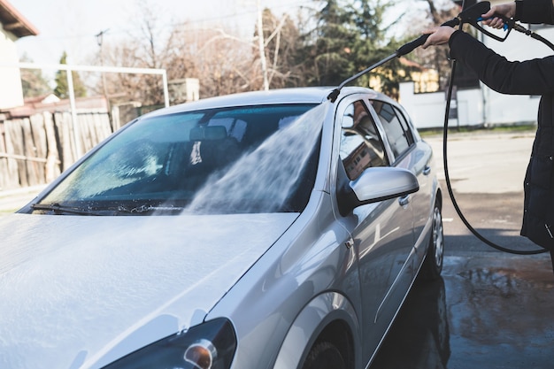 Lavado de coches limpieza del coche con agua a alta presión enfoque