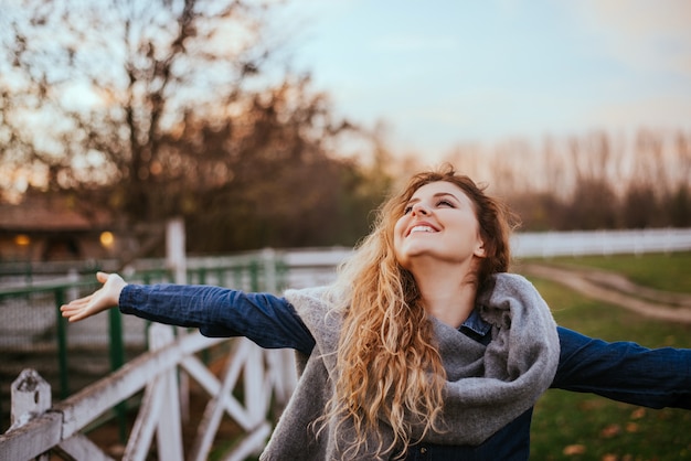 La libertad se siente bien. mujer alegre levantando las manos afuera. Foto Premium 