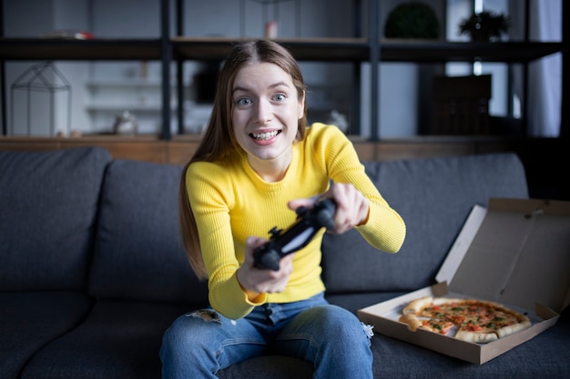 Linda Chica Juega En La Consola Y Come Pizza Foto Premium 