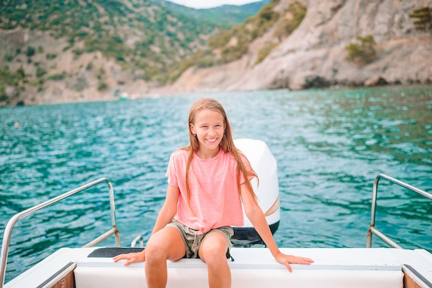 Linda chica sonriendo y disfrutando de navegar en barco en mar abierto | Foto Premium