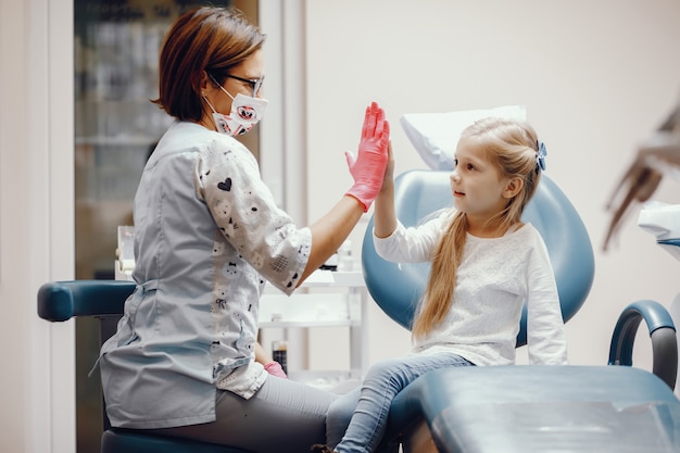 Linda niña sentada en la oficina del dentista Foto gratis