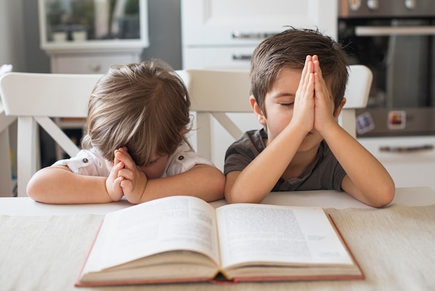 Lindos Niños Rezando Juntos En Casa | Foto Premium