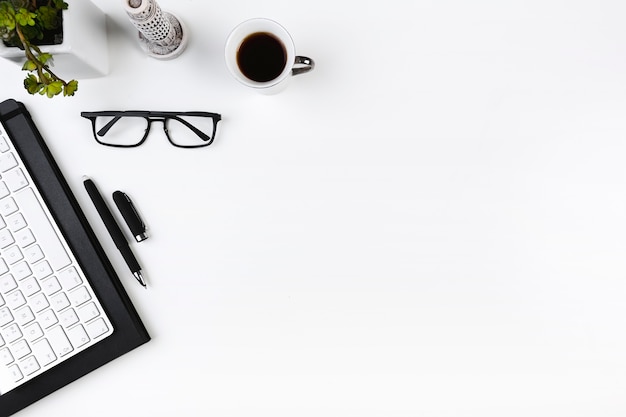 Lugar de trabajo de oficina con teclado y gafas