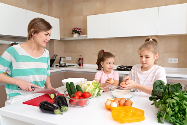 Madre Y Dos Hijas Cocinando En La Cocina Y Divirtiéndose Familia Feliz Y Concepto De Madre 