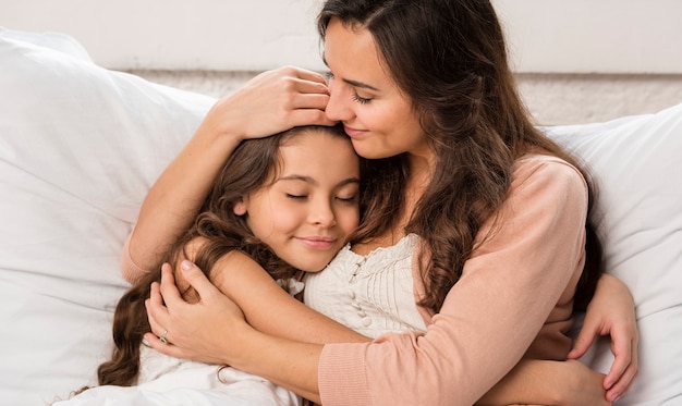 Madre E Hija Abrazándose En La Cama Foto Gratis 