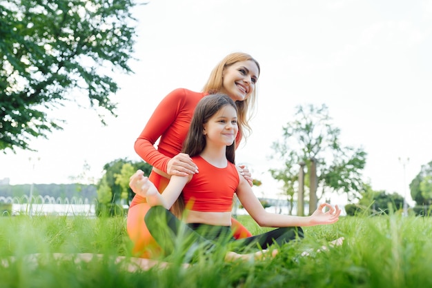 Madre E Hija Haciendo Ejercicios De Yoga Sobre El Césped En El Parque ...