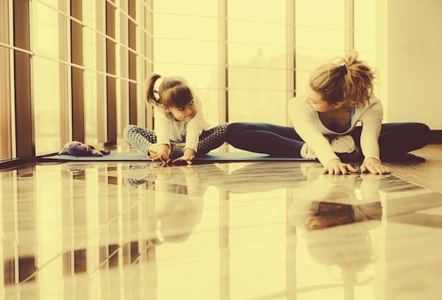 Madre e hija haciendo yoga en casa Foto gratis