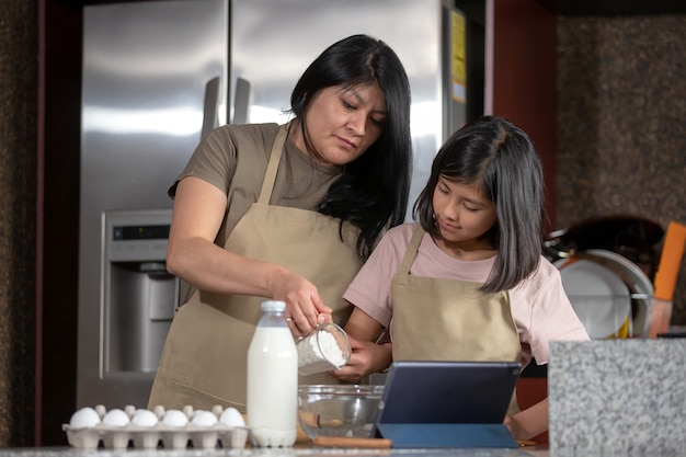 Madre E Hija Mexicana Cocinando En La Cocina Mirando La Receta En Una Tableta Foto Premium 