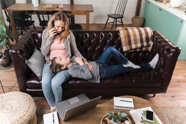 Madre E Hijo Descansando En El Sofá Foto Gratis 