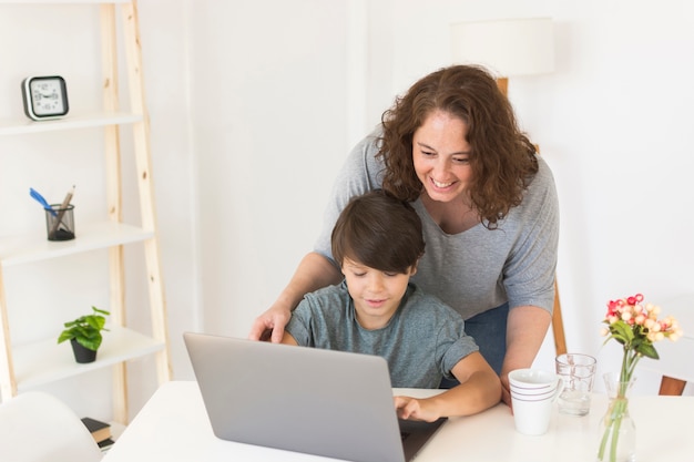 Madre E Hijo Mirando En La Computadora Portátil Foto Gratis 