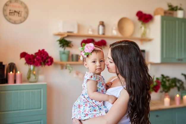 La Madre Y La Hija De La Familia Con Las Peonas Florecen En Cocina En