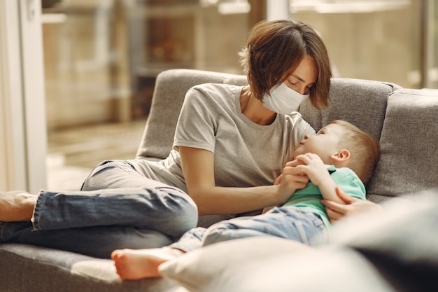 Madre con un hijo más pequeño sentado en su casa en cuarentena Foto gratis