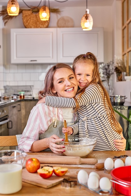 Madre Sonriente Con Hija Abrazando Mientras Cocina Preparando Masa Para Hornear Galletas 