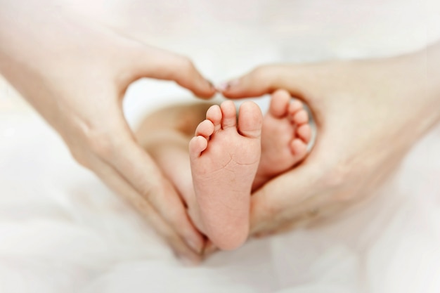 Madre Sosteniendo En Las Manos Los Pies Del Bebe Recien Nacido Forma De Corazon Amor Foto Premium