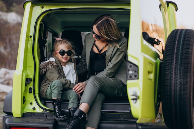 Madre con su pequeña hija sentada en la parte trasera del auto Foto gratis