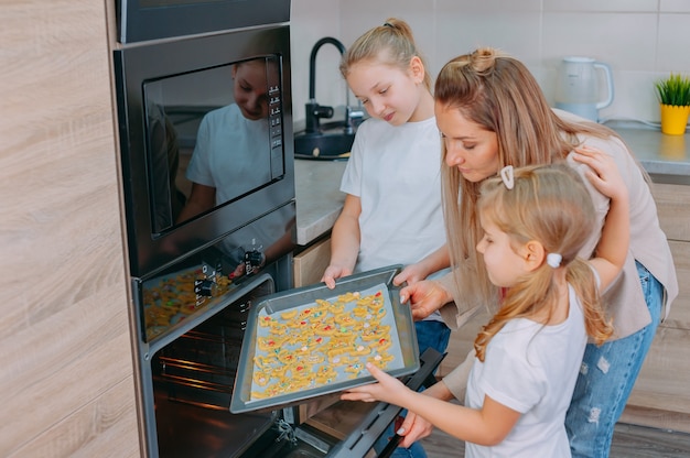 Mamá Les Enseña A Sus Hijas A Cocinar En La Cocina Foto Premium 