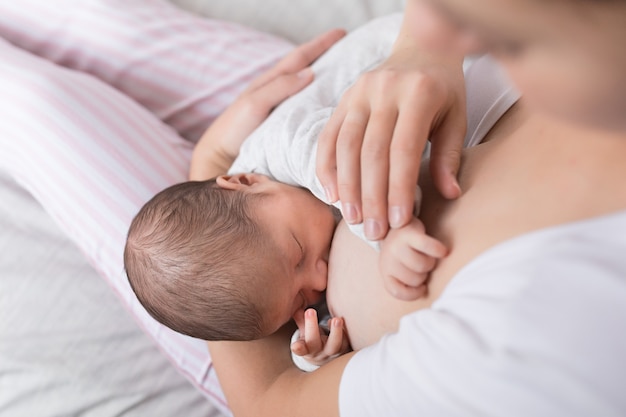 Mamá feliz abrazando a su bebé, concepto de lactancia. Foto Premium 