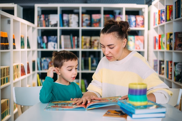 Mamá Y Su Pequeño Hijo El Hijo En Edad Preescolar Leen Juntos Libros Para Niños Foto Premium 7227