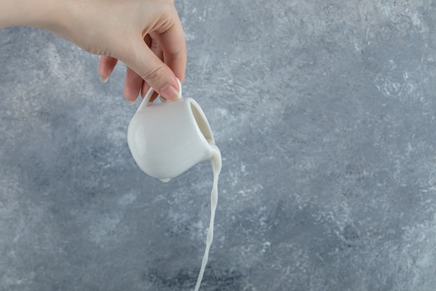 Mano Femenina Vertiendo Leche Fresca De Taza Pequeña Foto Gratis 8771