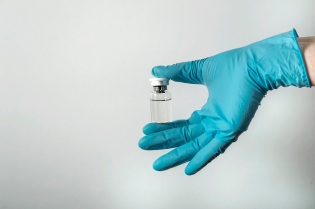 Una Mano En Un Guante Azul Médico Sostiene Una Ampolla Con Una Vacuna Contra La Infección Por 9115