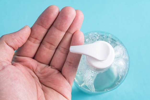 Mano del hombre en un recipiente con gel de alcohol Foto gratis