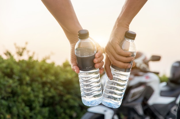 Video De La Botella Y La Bici Mano sosteniendo la botella de agua con bicicleta grande, vacaciones de