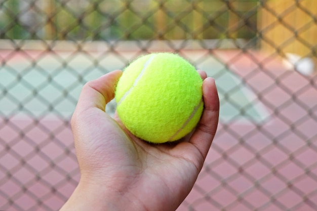 Mano sosteniendo la pelota de tenis | Foto Premium