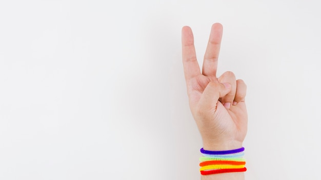 Mano de victoria con pulsera de la bandera del orgullo Foto gratis