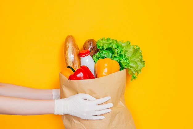 Las Manos Femeninas En Guantes Médicos Sostienen Una Bolsa De Papel Con Alimentos Verduras 6399