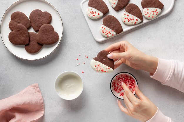 Manos femeninas haciendo galletas caseras en forma de corazón Foto