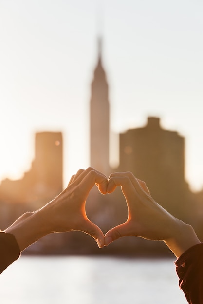 Manos en forma de corazón al atardecer, horizonte de nueva ...