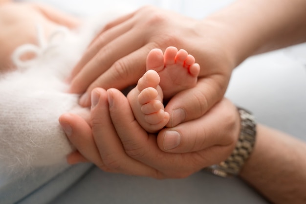 Manos De Los Padres Las Piernas Del Recien Nacido En Manos De Mama Y Papa Las