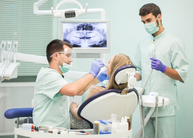 Medico Dentista Con Un Asistente De Trabajo En Una Clinica Dental Foto Premium