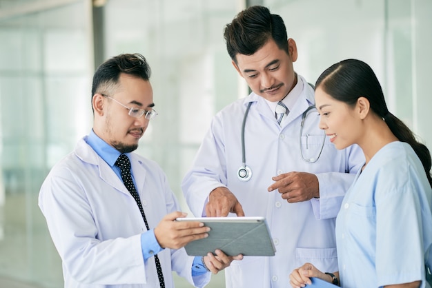 Médicos leyendo datos en tableta digital Foto gratis