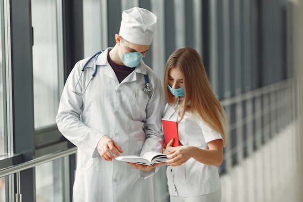 Los médicos con máscaras están discutiendo el problema en una sala. Foto gratis