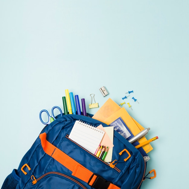 Mochila llena de accesorios escolares. Foto gratis