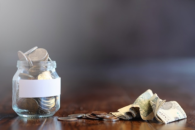 Monedas En Un Frasco De Vidrio Sobre Un Piso De Madera Ahorros De