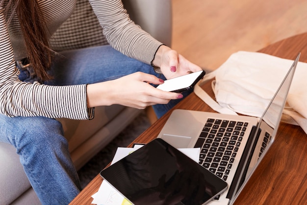 Mujer de alta visión teletrabajando y usando el teléfono móvil Foto gratis