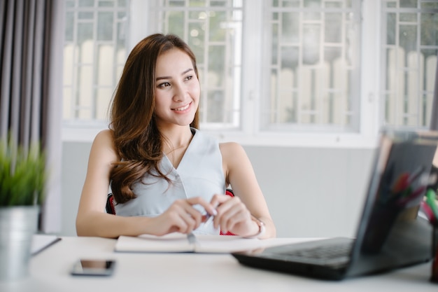 Mujer de asia trabajando desde casa en la computadora portátil ...