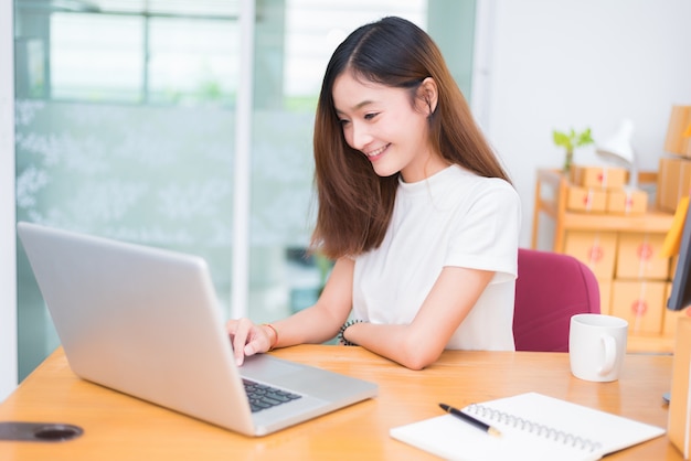 Mujer asiática disfrutar mientras usa computadoras portátiles e ...