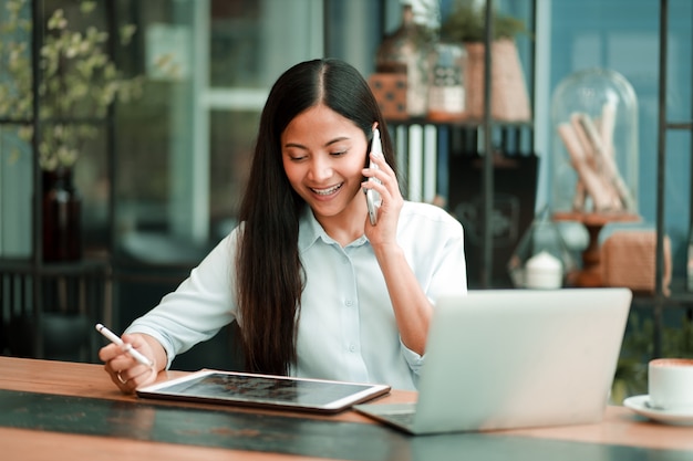 Mujer asiática que trabaja con la computadora portátil en la ...